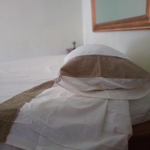 a bed with a blanket and a mirror on the wall at La Torre di Barbara in Ardea