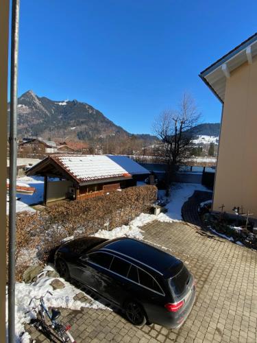 un coche negro estacionado frente a una casa en Alpen luaga, en Sonthofen