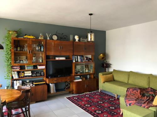 a living room with a couch and a television at Midcentury modern 1 bedroom apartment in Tirana in Tirana