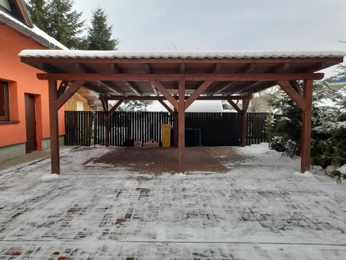a wooden pergola in front of a house at Ubytovanie v Lihôtke in Oravský Podzámok