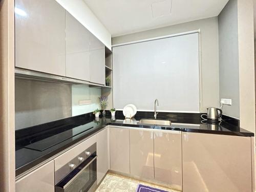 a kitchen with white cabinets and a sink at CHARMING & COZY PREMIER SUITES @ VISTA RESIDENCE in Genting Highlands