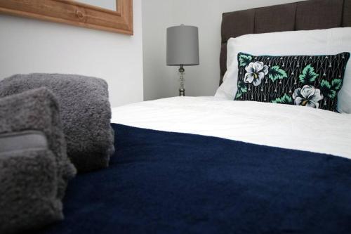 a bed with a blue blanket and a pillow on it at Goodrich Mews in Newport