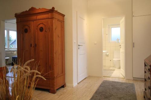 ein Badezimmer mit einem Holzschrank und einem WC in der Unterkunft Ferienhaus Schönhagen Strand in Schönhagen