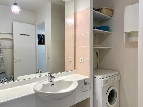 une salle de bain avec un lavabo et une machine à laver dans l'établissement REF 025 Appartement pour six personnes très belle vue mer plage du Fogeo, à Arzon
