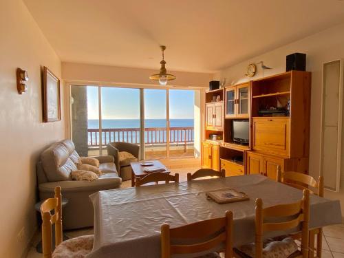 - un salon avec une table et une vue sur l'océan dans l'établissement REF 025 Appartement pour six personnes très belle vue mer plage du Fogeo, à Arzon