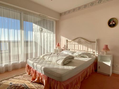 une chambre avec un lit et une grande fenêtre dans l'établissement REF 025 Appartement pour six personnes très belle vue mer plage du Fogeo, à Arzon
