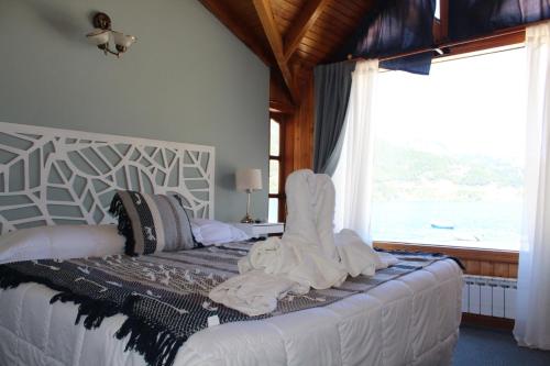 ein Schlafzimmer mit einem Bett mit Handtüchern darauf in der Unterkunft Cabañas Lago Soñado de los Andes in San Martín de los Andes