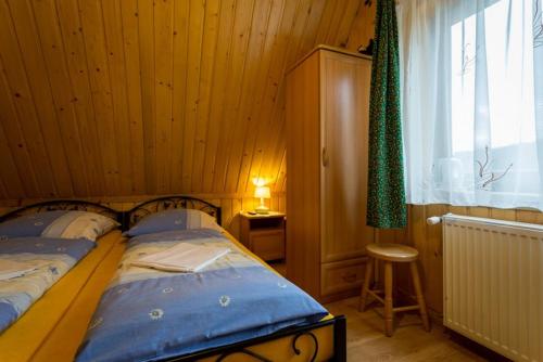 a bedroom with a bed in a wooden room at DW Lassakówka in Suche