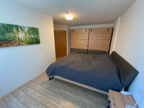 1 dormitorio con 1 cama y una pintura en la pared en Alpen luaga, en Sonthofen