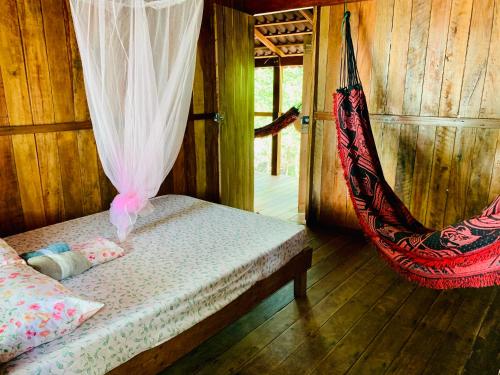 a room with a bed and a hammock in it at FlowMove Retreat Algodoal in Algodoal