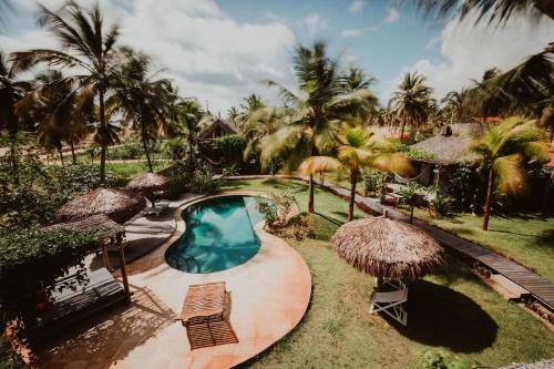 a resort with a swimming pool and palm trees at Pousada Vayú in Icaraí