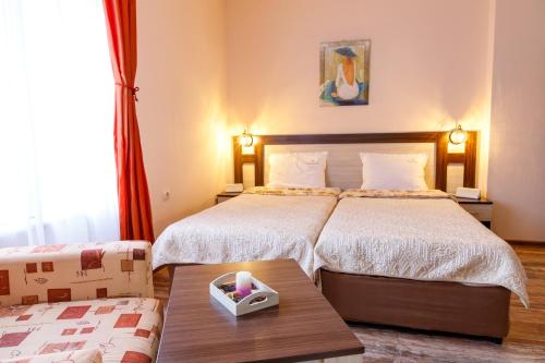una habitación de hotel con dos camas y una mesa en Villa Gamma, en Pavel Banya