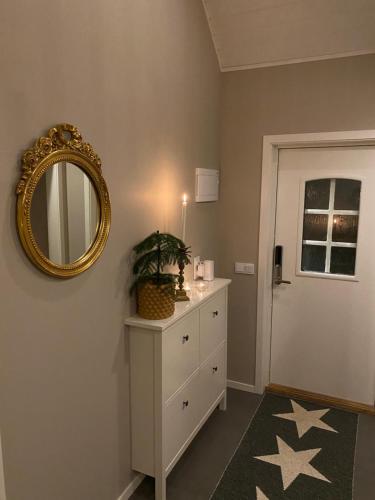 Zimmer mit einer weißen Kommode und einem Spiegel in der Unterkunft Attefallshus på Ängö i Kalmar in Kalmar