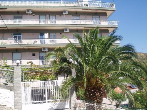 a tall building with a palm tree in front of it at Rania House in Neos Marmaras