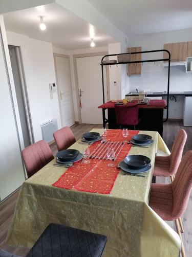 a dining room table with a red table cloth on it at superbe apart vue panoramique sur les pyrénées,balcon plein sud in Font-Romeu-Odeillo-Via