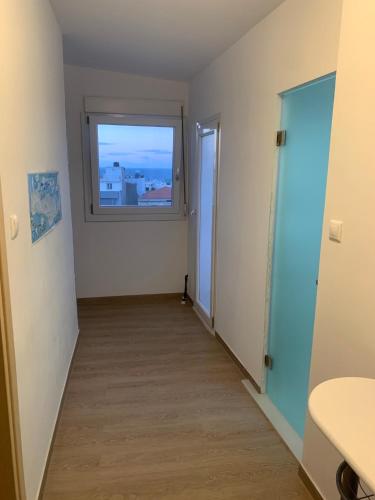 an empty room with a window and a hallway at Private Rooms with a Beautiful Veranda in Heraklio
