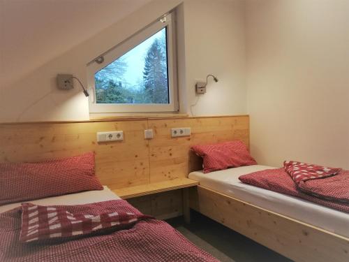 2 Betten in einem Zimmer mit Fenster in der Unterkunft Fewo bei Reuters - Haus Tellkoppe in Waldidylle