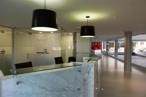 a lobby with two black lights and a marble counter at Regency Way Montevideo Hotel in Montevideo