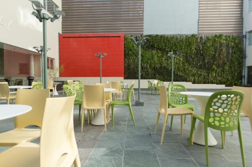 a restaurant with tables and chairs and a red wall at Regency Way Montevideo Hotel in Montevideo