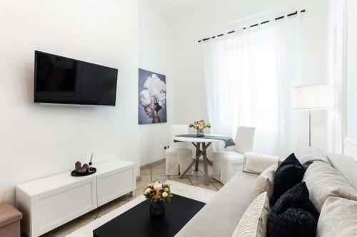 a white living room with a couch and a table at Appartamento Corfù in Lido di Ostia