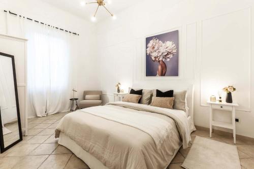 a white bedroom with a large bed in it at Appartamento Corfù in Lido di Ostia