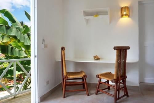 two chairs and a table in a room with a window at Le BDM PLAYITA in Las Galeras