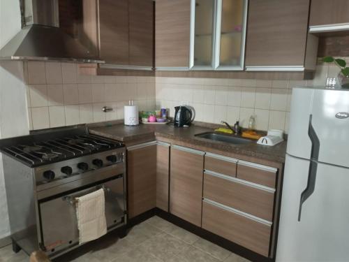 a kitchen with a stove and a refrigerator at Amaru Apart in La Consulta