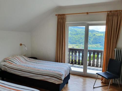 a bedroom with a bed and a large window at Haus Brunner in Döbriach