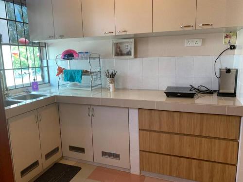 a kitchen with white cabinets and a counter top at 4-6人家庭 Cozy Home @ Kutoba Square in Tawau