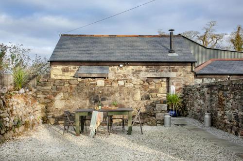 a stone building with a table in front of it at The Barn in Lanhydrock, Bodmin in Bodmin