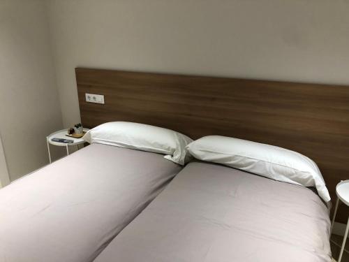 a bed with two pillows on it in a bedroom at Pensión La Castellana in Logroño