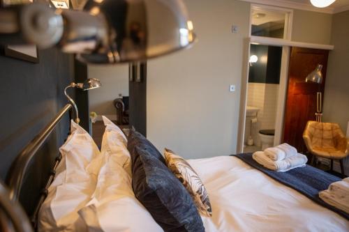 a bedroom with a bed with pillows and a mirror at Haweswater Hotel in Bampton