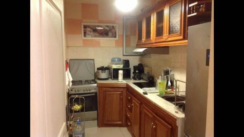 a kitchen with wooden cabinets and a stove top oven at JOLI APPARTEMENT A DAKAR,ESPACES MAMELLE in Dakar