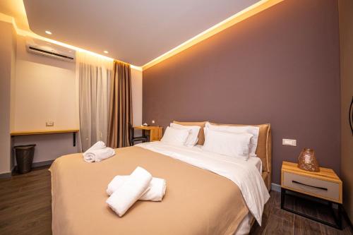 een hotelkamer met een bed met handdoeken erop bij Blloku Unique Apartments in Tirana