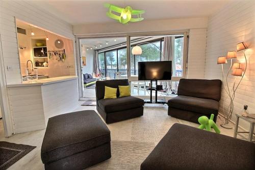 un salon avec deux chaises et une télévision dans l'établissement Cocoon, à Soorts-Hossegor