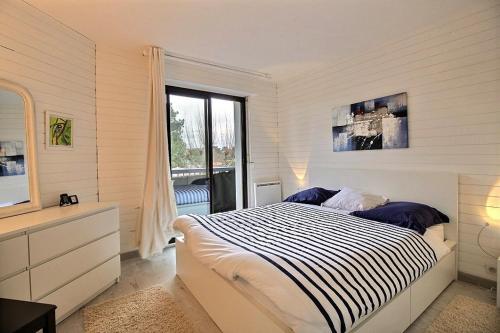 une chambre avec un lit et une grande fenêtre dans l'établissement Cocoon, à Soorts-Hossegor