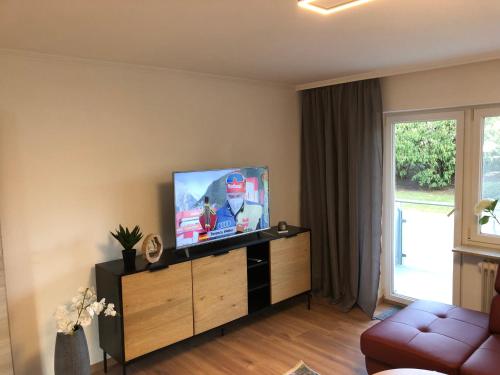 a living room with a flat screen tv on a cabinet at Four Seasons Bodensee in Eriskirch