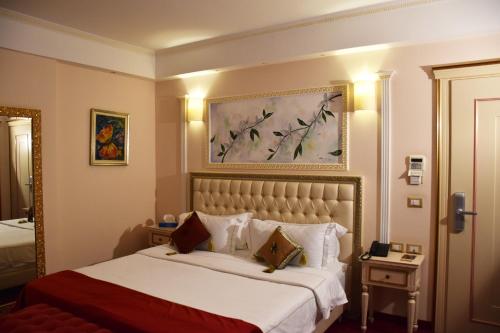 a hotel room with a bed and a painting on the wall at 2 KITARRAT Boutique Hotel & SPA in Durrës