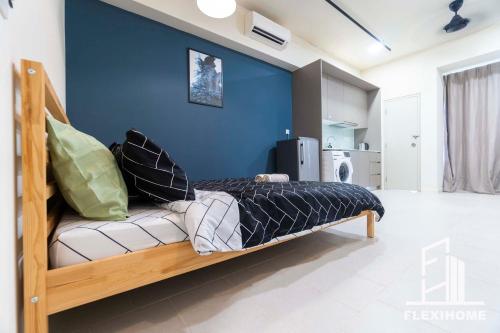 a bed in a room with a blue wall at 9am-5pm, SAME DAY CHECK IN AND CHECK OUT, Work from Home, Comfy & Quiet Tamarind Suites-Cyberjaya by Flexihome-MY, in Cyberjaya