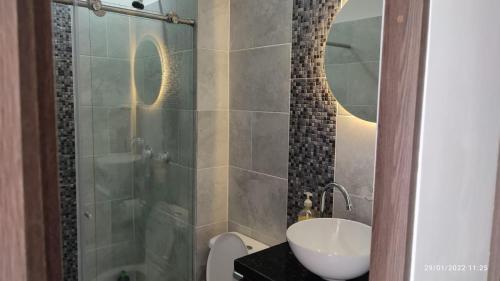 La salle de bains est pourvue d'une douche, d'un lavabo et de toilettes. dans l'établissement Acogedora y Hermosa Casa Familiar con WiFi, à Ibagué