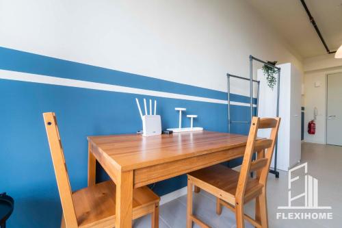 a dining room with a wooden table and two chairs at 9am-5pm, SAME DAY CHECK IN AND CHECK OUT, Work from Home, Comfy & Quiet Tamarind Suites-Cyberjaya by Flexihome-MY, in Cyberjaya