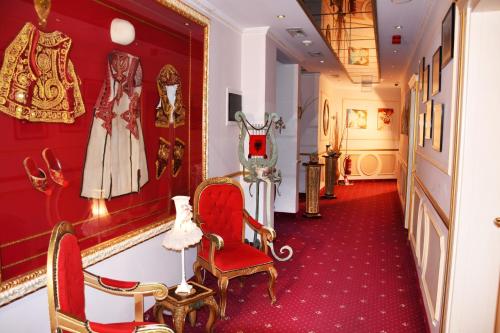a hallway with red carpeting and a red chair and a red wall at 2 KITARRAT Boutique Hotel & SPA in Durrës