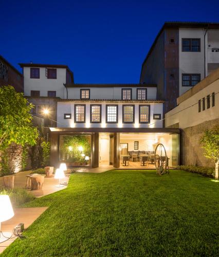 a house with a green yard at night at Casa do Juncal in Guimarães