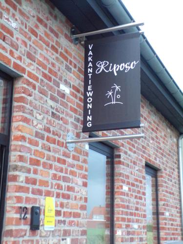 a sign hanging from the side of a brick building at Riposo in Poperinge
