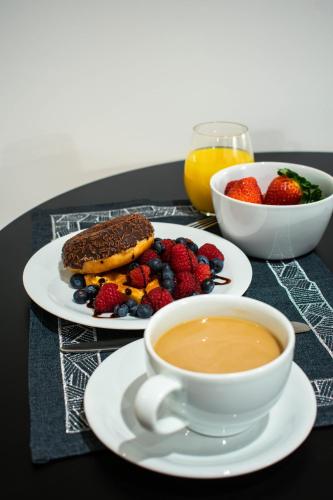 a table with a cup of coffee and a plate of fruit at Apartments24 Spordi in Rakvere
