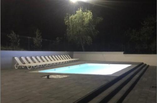 una piscina vacía por la noche con bancos alrededor en SPapartmens en Polyana