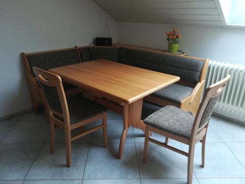 uma mesa de madeira e duas cadeiras com uma mesa de madeira e chairsuggest em Fewo Salem-Mimmenhausen em Salem