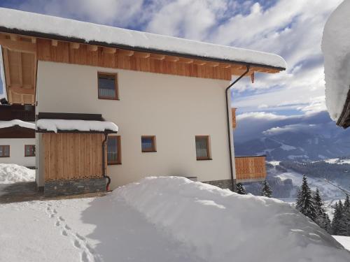 a snow covered building on top of a mountain at Ferienhaus Weitblick in Flachau