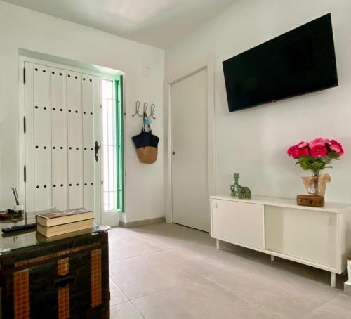 Una sala de estar con un televisor en una pared blanca. en An ca Los Lolos 45, en Frigiliana