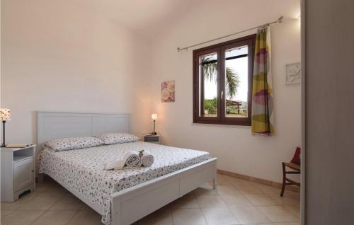 a white bedroom with a bed and a window at VILLA SICILIA in Custonaci